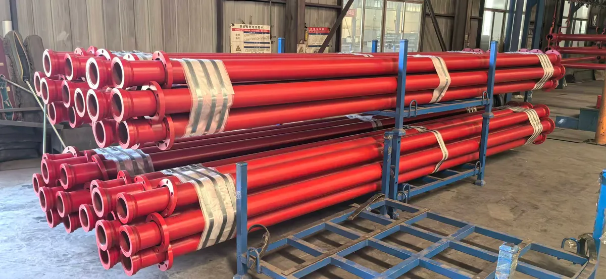 Flanged bimetal wear-resistant pipes stacked on racks in the workshop