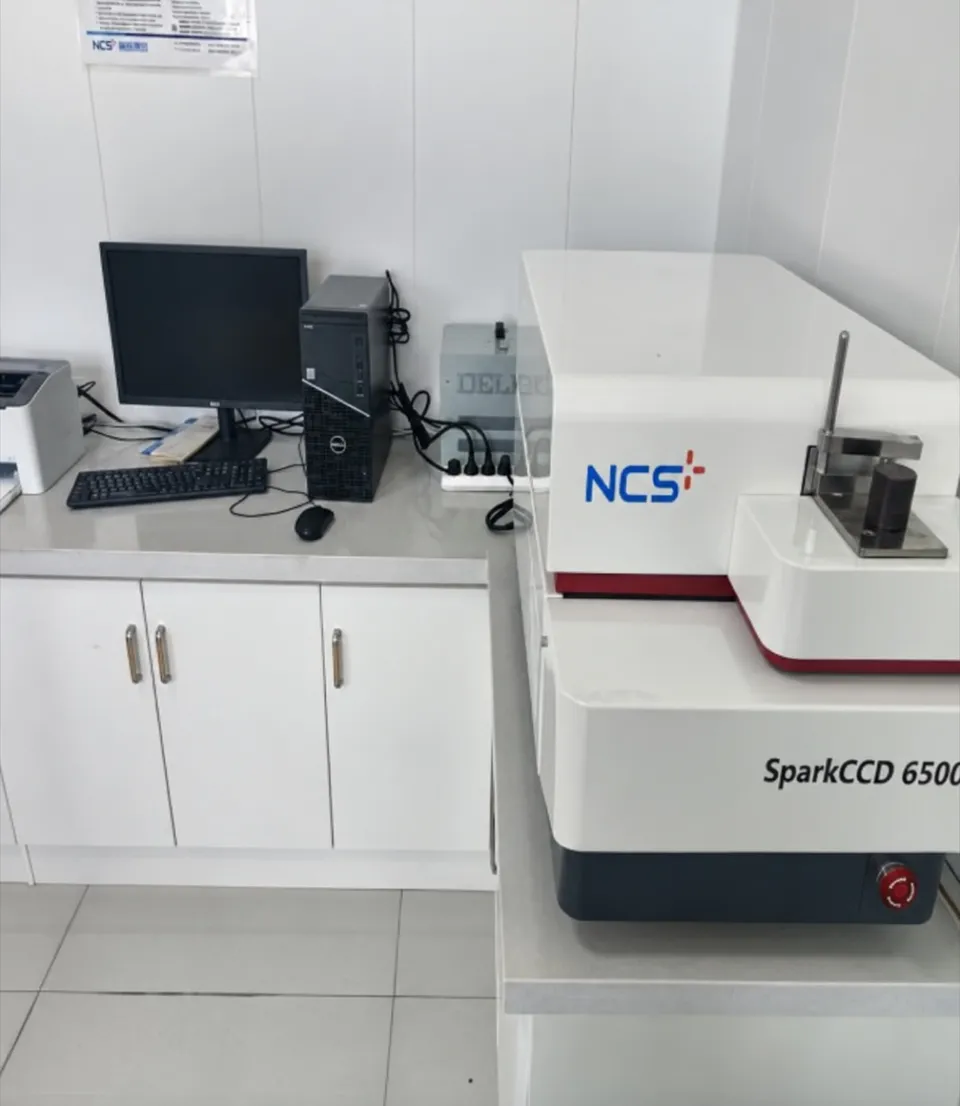 Spark optical emission spectrometer on its bench, with the control computer beside it